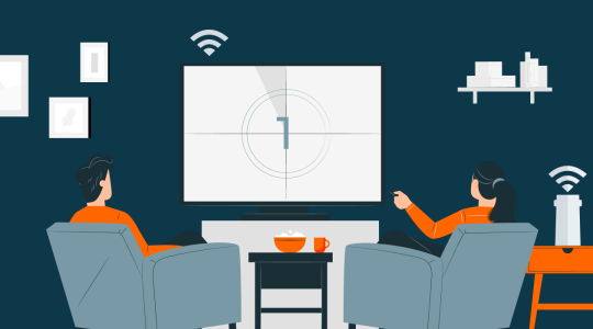 Zwei Personen auf Sesseln schauen auf Fernseher, zwischen ihnen ein Tisch mit Popcorn.