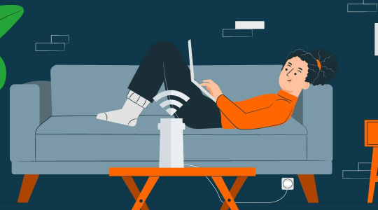 Eine Frau sitzt mit Laptop auf dem Sofa. Im Vordergrund steht ein mobiler Router fürs WLAN.