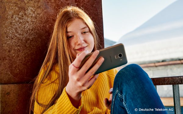 Teenagerin schaut auf ihr Smartphone-Display.