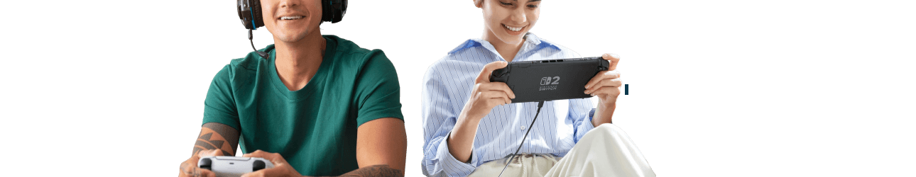 Ein Mann mit Kopfh�rern spielt mit einem Konsolencontroller, neben ihm sitzt eine Frau und h�lt l�chelnd eine tragbare Spielekonsole in den H�nden.